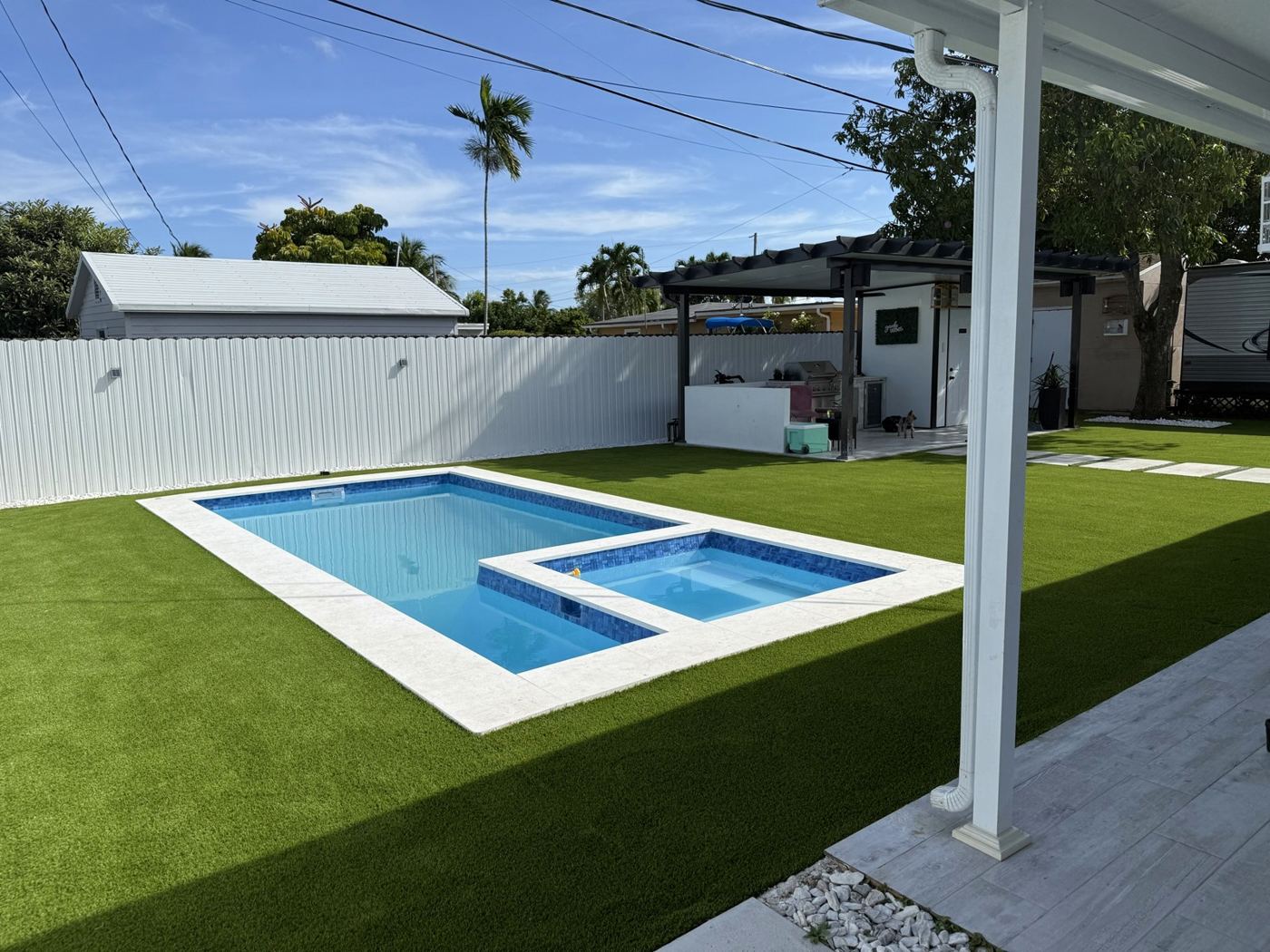 Patio con piscina y grama artificial instalada por Destefano