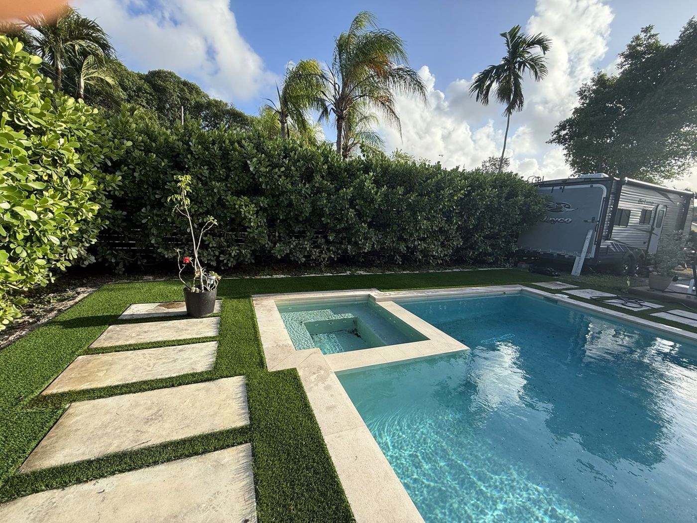 Piscina con losas y grama artificial